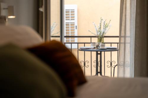 a table with a vase of flowers on a balcony at Degrassi Square Apartments in Vrsar