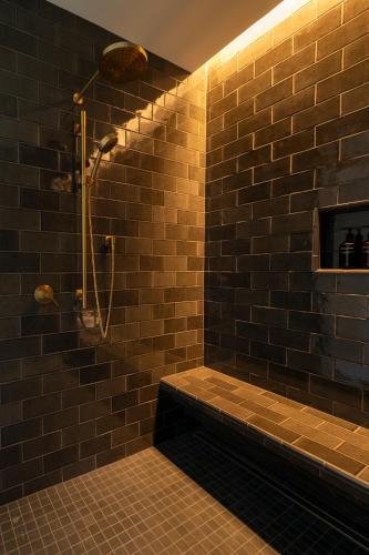 a brown tiled bathroom with a shower and a tub at Larch House in Whitefish