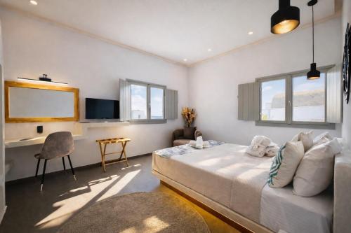 a bedroom with a bed and a desk in it at Tiara Suites Fira - Cycladic & Cave in Fira
