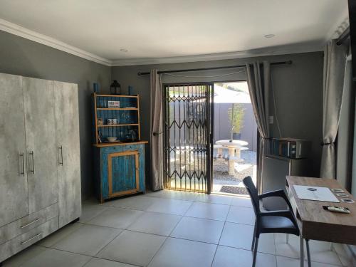a dining room with a table and a door to a patio at Haleys Guest House in Benoni