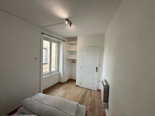 an empty room with a bed and a window at Appart' Val 2 in Beaumont