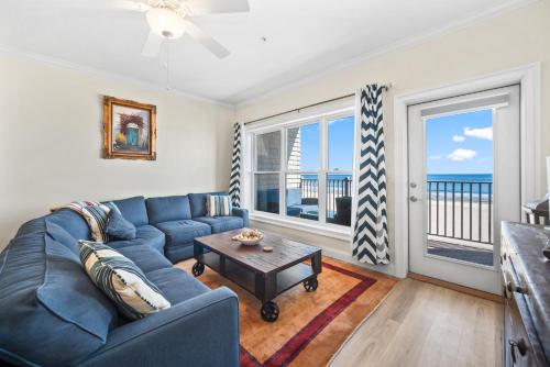 a living room with a blue couch and a table at Hampton Beach OCEAN FRONT Condo at the Surf in Hampton