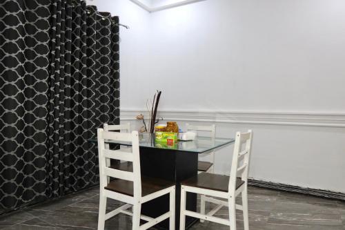 una sala da pranzo con un tavolo di vetro e due sedie di Lebon Paradise a Accra