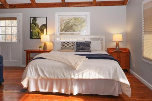 a bedroom with a large bed with two lamps at Burnett Ranch Cabins- Prickly Pear in Wimberley