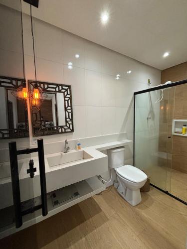 a bathroom with a sink and a toilet and a mirror at Casa Aurora Provetá - Ilha Grande in Angra dos Reis