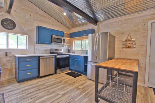 a kitchen with blue cabinets and a wooden floor at Blue Jay Getaway in Blanco