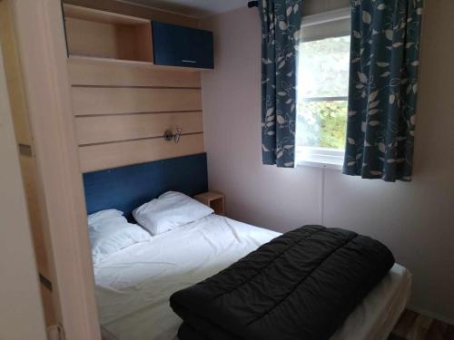a small bedroom with a bed with a window at MOBIL-HOME n 95 in Barrême