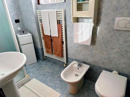 a bathroom with a white toilet and a sink at Casa Raggio di Sole in Toscolano Maderno