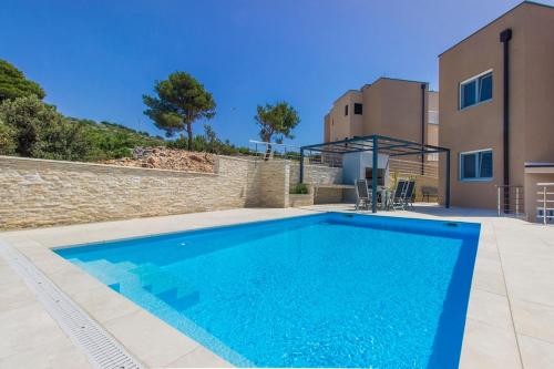a swimming pool in front of a house at Villa Ilenia in Murter