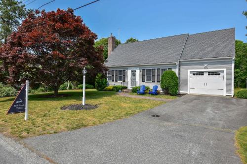a house with a garage and a sign in the driveway at Spacious w Beautiful Yard & Dogs Welcome in Harwich