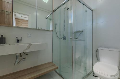 a bathroom with a glass shower and a toilet at Apartamento 2 suítes C/Piscina in Bombinhas