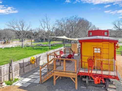 a small train house sitting next to a fence at Caboose on the Square in Wimberley