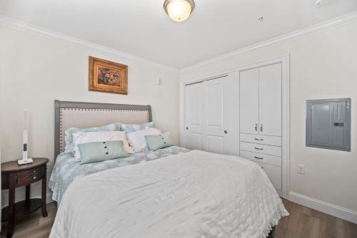 a white bedroom with a bed and a tv at Hampton Beach OCEAN FRONT Condo at the Surf in Hampton