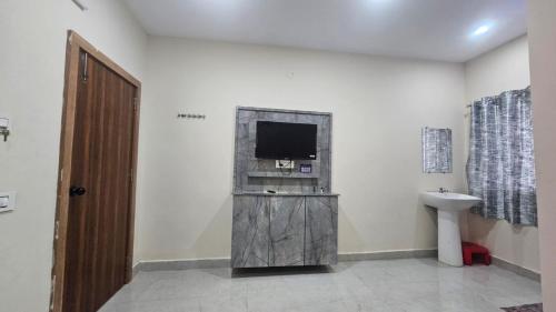 a bathroom with a tv and a sink and a toilet at hotel Mansion grand in Khammam