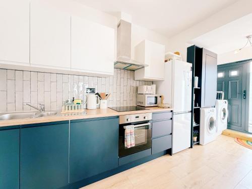 a kitchen with blue cabinets and white appliances at Modern Apartment, Central Brighton Breakaway - Friends, Families, Work in Brighton & Hove
