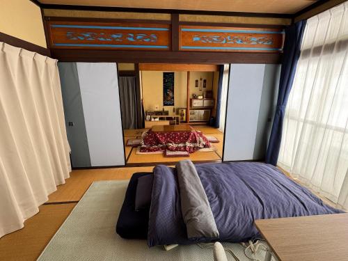a bedroom with a large bed in a room at Blue Art Satoyama Retreat in Ōasa
