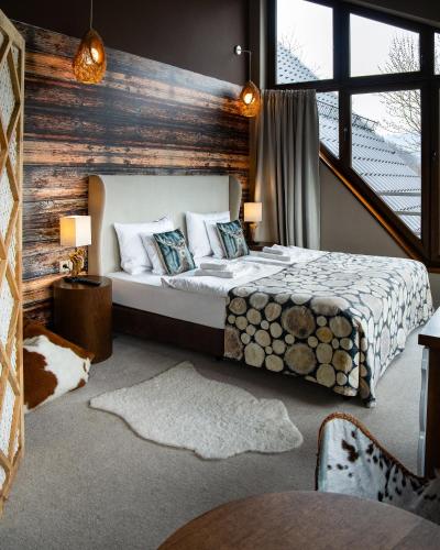 a bedroom with a bed and a wooden wall at Hotel Piwniczna SPA&Conference in Piwniczna-Zdrój