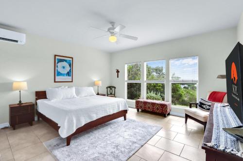 a bedroom with a bed and a chair and windows at Canyon Breeze in Canyon Lake
