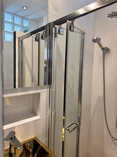 a bathroom with a shower with a mirror and a sink at Kopalnia soli apartments in Wieliczka