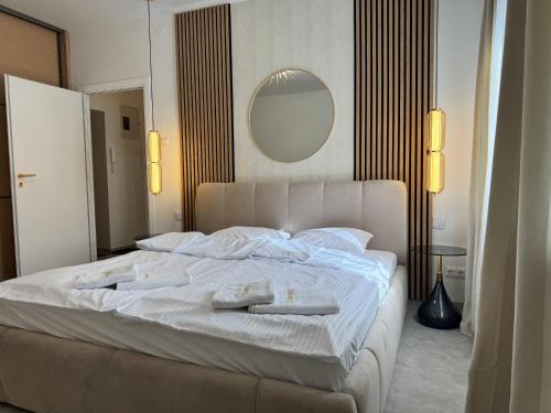 a bedroom with a large white bed with towels on it at Kopalnia soli apartments in Wieliczka