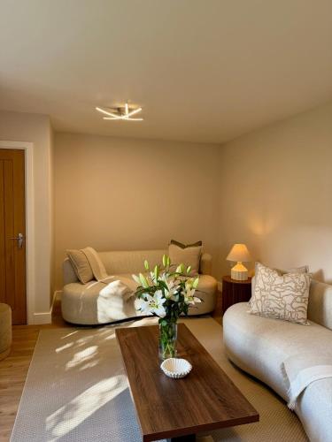 a living room with a couch and a vase of flowers on a table at Spacious Modern 4BR Nottingham City- QMC- Uni in Nottingham