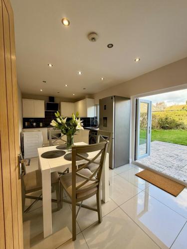 a kitchen with a table with a vase of flowers on it at Spacious Modern 4BR Nottingham City- QMC- Uni in Nottingham