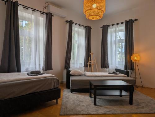 two beds in a room with windows and a table at Flataid Apartmenthaus Tieschen in Tieschen