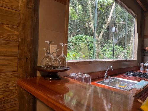 a kitchen with a counter with a sink and a window at Chalé Shangri-la in Paraty