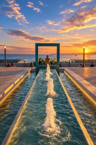 Ein Mann steht vor einem Wasserbrunnen. in der Unterkunft Level 4 in Antibes