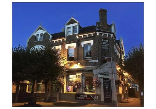 a large brick building on a street at night at Forest Gate Hotel - Free Parking limited spaces in London