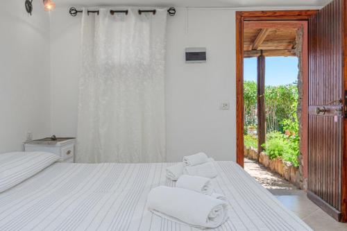 a bedroom with a bed and two white chairs at Villaggio Marineledda in Santa Marinella