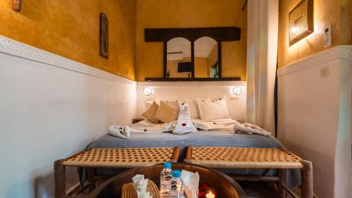 マラケシュにあるRiad Dama & Spaの壁に鏡が付いたベッドのある部屋