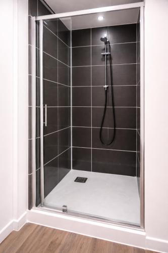 a shower with a glass door in a bathroom at Petit cocon moderne Cuisine équipée TV WIFI in Roubaix