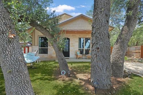 a house with a group of trees in front of it at Comal Cottage in Canyon Lake