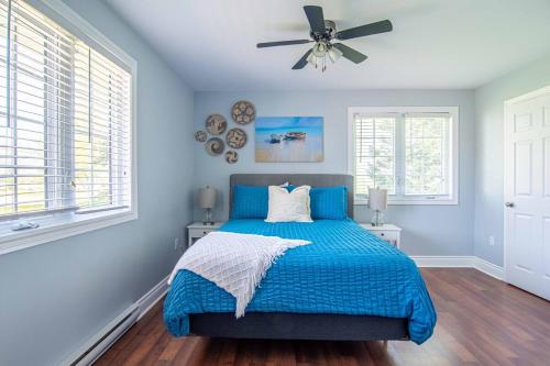 a bedroom with a blue bed and a ceiling fan at Apartment in Prince Edward County - 'Suite Spot' in Picton