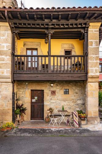a building with a balcony on top of it at Casa Rural Moradiellos-Cabrales Axtur 4 personas con vistas in Arenas de Cabrales