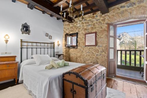 a bedroom with a large bed and a stone wall at Casa Rural Moradiellos-Cabrales Axtur 4 personas con vistas in Arenas de Cabrales