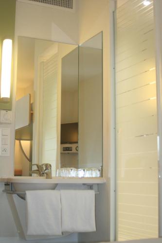 een badkamer met een wastafel en een spiegel bij ibis budget Niort - La Crèche in La Creche