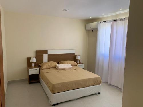 a bedroom with a bed and two night stands with two lamps at Condominio cortico in Mendoza