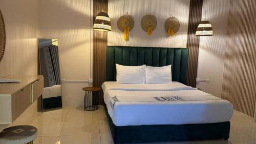 a bedroom with a large bed with a green headboard at نوليتا للشقق الفندقية in Abha