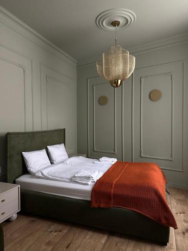 a bed in a bedroom with a chandelier at K2 Apartment in Tarnów
