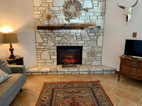 a living room with a stone fireplace at La Vista in Canyon Lake