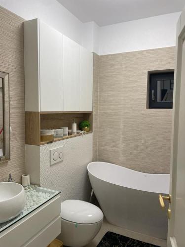 a bathroom with a tub and a toilet and a sink at Luxury Promenada Craiova in Craiova