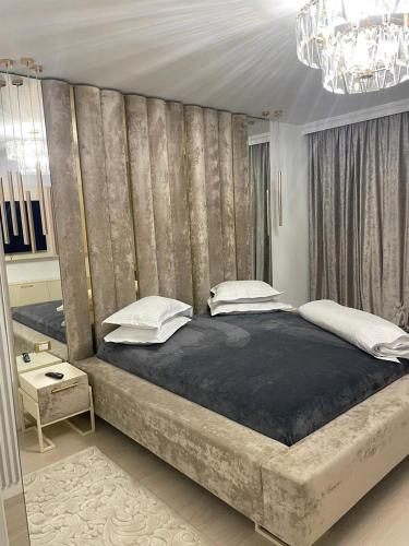 a large bed in a bedroom with a wall at Luxury Promenada Craiova in Craiova