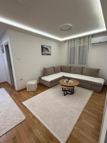 a living room with a couch and a table at Phenix Apartments Lux Parking FREE in Podgorica