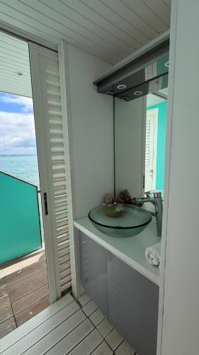 a bathroom with a sink and a view of the ocean at Lagoon Lodge Caraïbes -Lodge flottant sur lagon avec vue mer in Saint-François