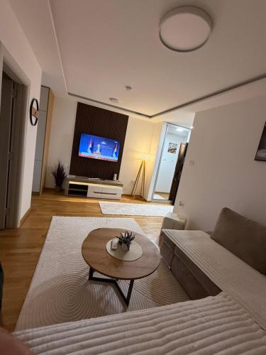 a living room with a couch and a table at Phenix Apartments Lux Parking FREE in Podgorica