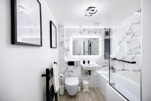 a white bathroom with a sink and a toilet at HollyTree - Family and Business Stay with parking in Cambridge