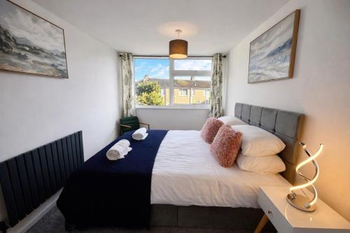 a bedroom with a large bed with a window at HollyTree - Family and Business Stay with parking in Cambridge