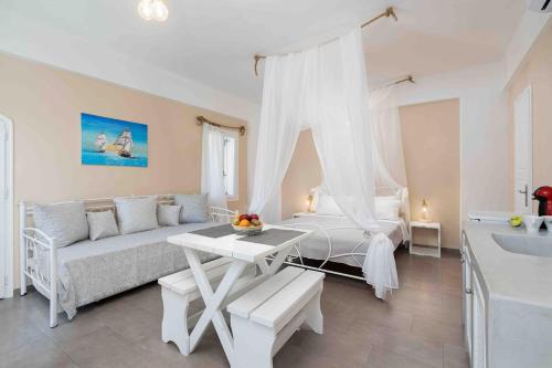 a white living room with a couch and a bed at Santa Irini 1 in Vourvoúlos